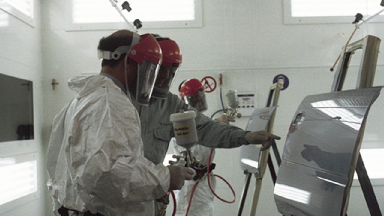 Workers spraying paint on Toyota door