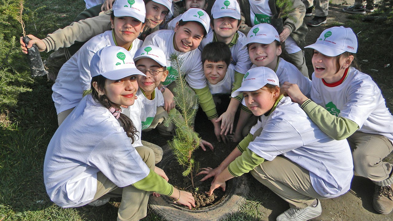 Kids reducing impact on environment by planting trees