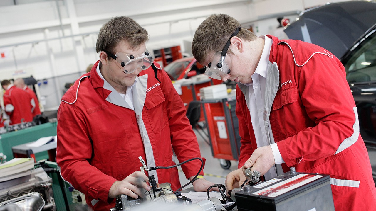 Two Toyota plant workers checking quality