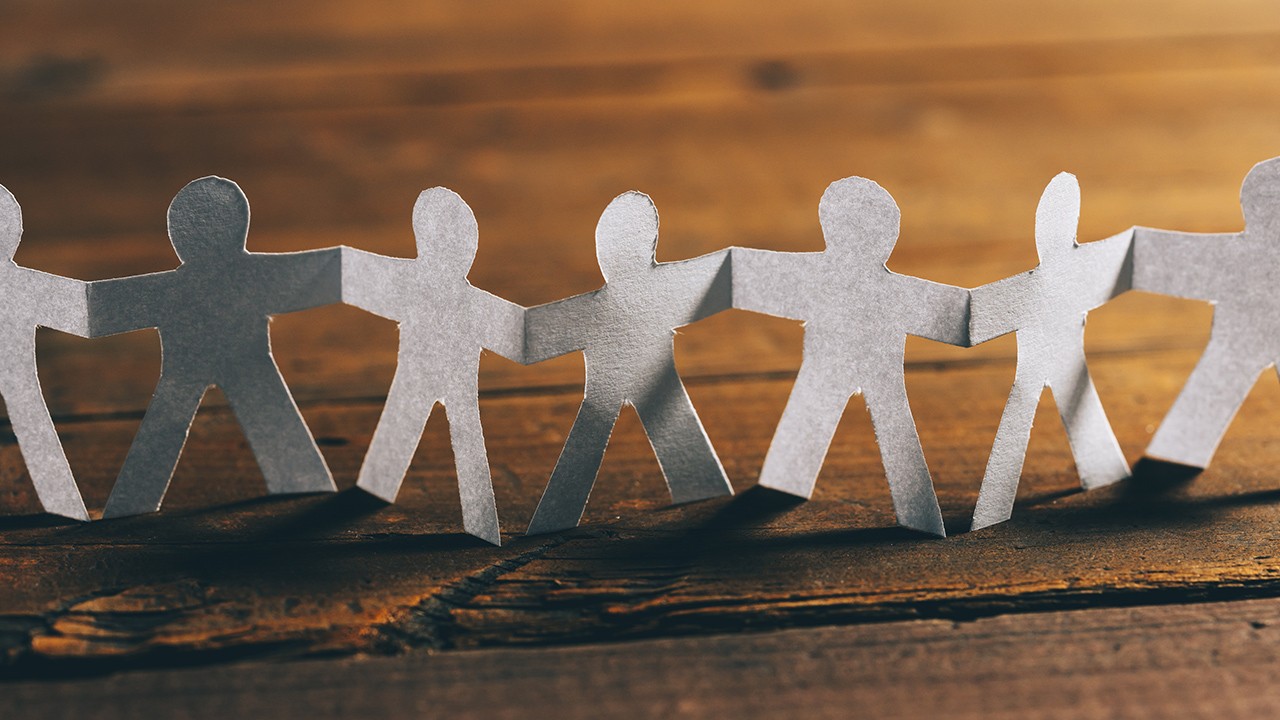 Showing papercut of group of people holding hands