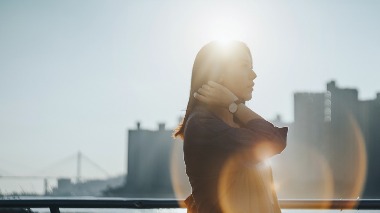 Woman in evening sun with city skyline