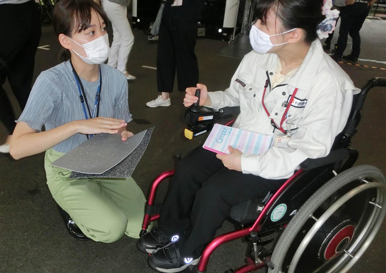 toyota employee having a conversation about the flooring materials with a wheelchair user