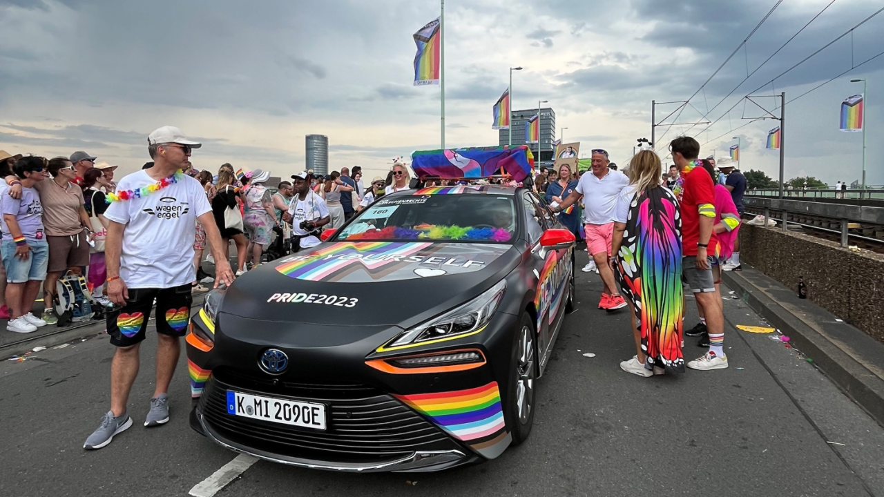 Toyota team with Toyota Mirai dressed in rainbow at the Cologne Pride March